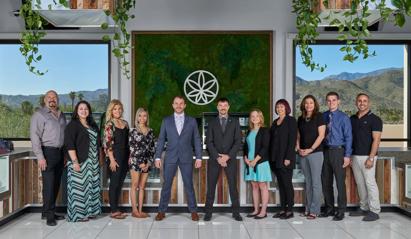 Commercial team photo — a staff lineup inside a Palm Springs storefront