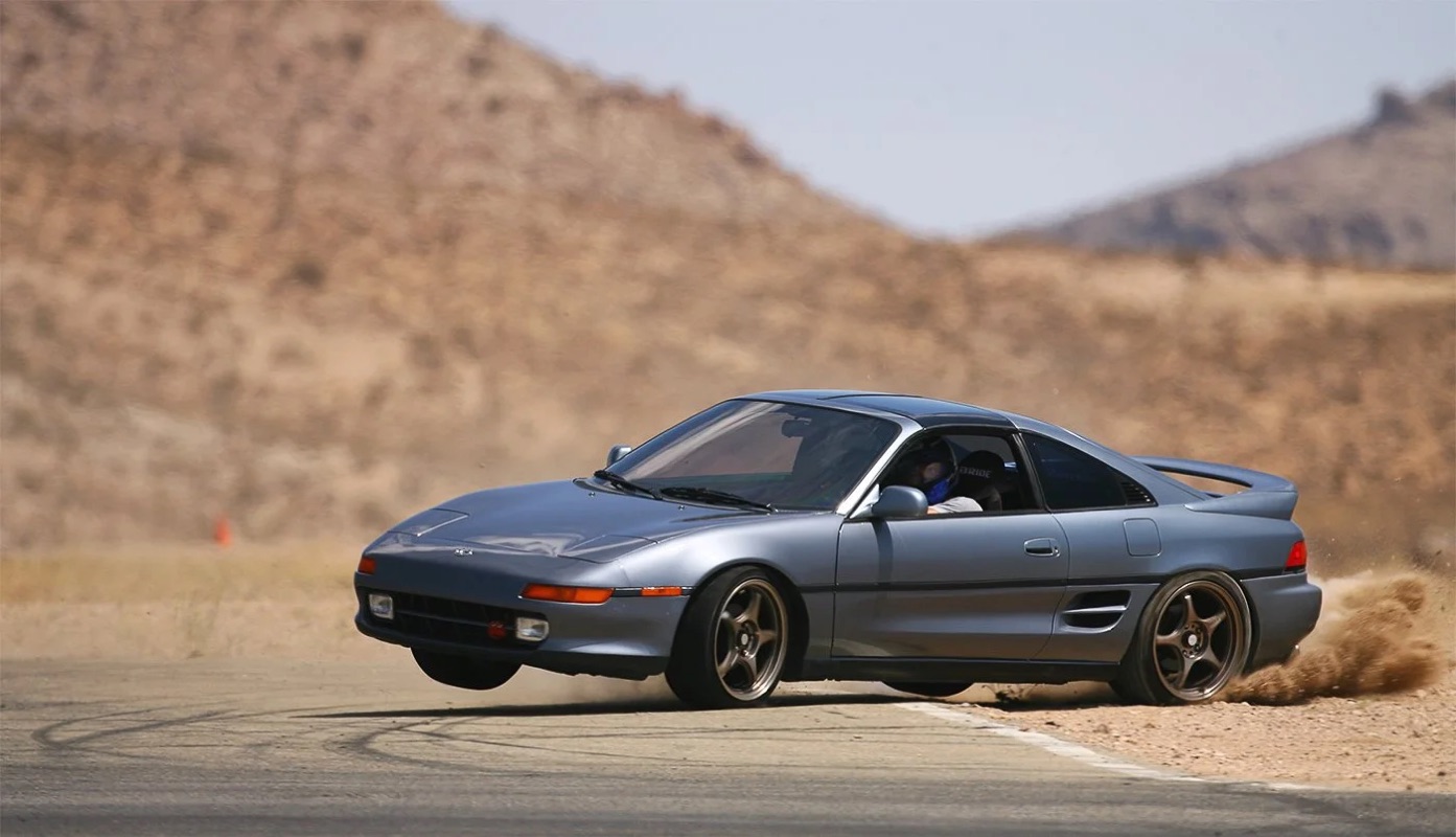 Motorsport action — a Toyota MR2 cornering on three wheels at the Streets of Willow