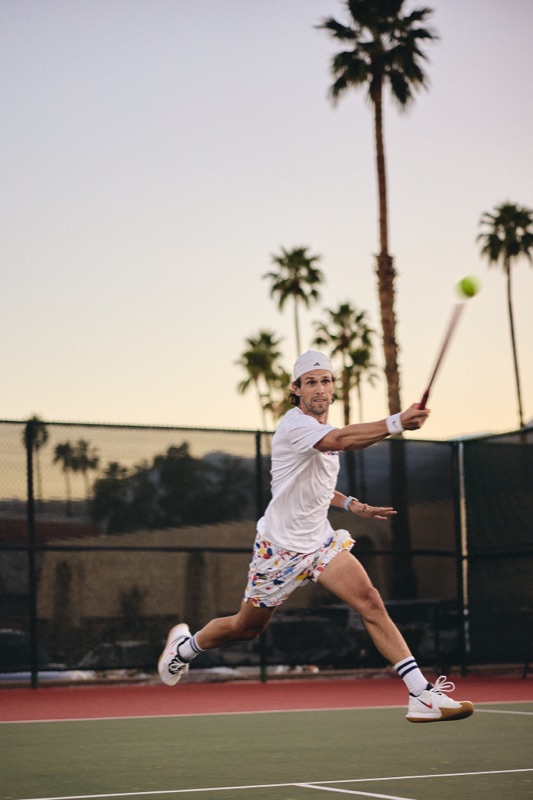 Tennis action at CC Tennis Club — a player lunging into a forehand at dusk